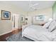 Bright bedroom with hardwood floors, white trim, ceiling fan, and walk-in closet access at 10069 Lake Miona Way, Oxford, FL 34484