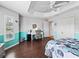 Bright bedroom with tray ceiling, hardwood floors, shutters, coastal blue paint, and desk at 10069 Lake Miona Way, Oxford, FL 34484