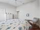 Comfortable bedroom featuring hardwood floors, ceiling fan, and coastal décor at 10069 Lake Miona Way, Oxford, FL 34484