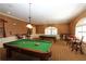 Billiard room with multiple pool tables, seating areas, and warm lighting for a relaxing atmosphere at 10069 Lake Miona Way, Oxford, FL 34484
