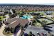 Aerial view of a luxurious community pool area with multiple pools, tennis courts, and well-maintained landscaping at 10069 Lake Miona Way, Oxford, FL 34484