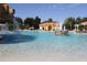 Inviting community pool area with a rock waterfall feature, set against a backdrop of charming buildings at 10069 Lake Miona Way, Oxford, FL 34484
