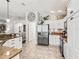 A kitchen with granite countertops, stainless appliances, white cabinetry, and open flow to dining area at 10069 Lake Miona Way, Oxford, FL 34484