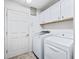 Bright laundry room features modern washer and dryer, white cabinets for storage, and access door to the rest of the house at 10069 Lake Miona Way, Oxford, FL 34484