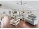 Bright, open living room featuring hardwood floors and comfortable seating with easy access to kitchen and dining at 10069 Lake Miona Way, Oxford, FL 34484