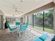Enclosed patio with comfortable seating area and a fan, perfect for relaxing and entertaining guests at 10069 Lake Miona Way, Oxford, FL 34484