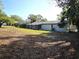 Spacious backyard featuring a screened in porch and mature trees providing ample shade at 104 N Oakland Ave, Clermont, FL 34715
