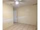 This bedroom features tile floors, neutral walls, a ceiling fan and a door leading to another room at 104 N Oakland Ave, Clermont, FL 34715