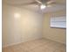 Cozy bedroom with tile floors, a ceiling fan, a window letting in natural light, and neutral walls at 104 N Oakland Ave, Clermont, FL 34715