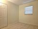 This bedroom features tile floors, a window letting in natural light, neutral walls, and a closet at 104 N Oakland Ave, Clermont, FL 34715