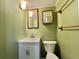 Cozy bathroom with wainscotting, single sink vanity, square mirrors and updated fixtures at 104 Valencia Cv, Leesburg, FL 34748