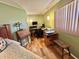 Bedroom featuring hardwood floors, desk, and ample natural light at 104 Valencia Cv, Leesburg, FL 34748