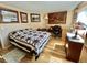 Comfortable bedroom with a decorative quilt, neutral walls, with artwork, and a home office area with desk at 104 Valencia Cv, Leesburg, FL 34748