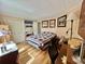 Bright bedroom featuring wood floors, neutral walls, and a functional office area with a desk and storage at 104 Valencia Cv, Leesburg, FL 34748