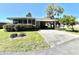 Well-maintained home with lush landscaping, a covered carport, and a welcoming entrance at 104 Valencia Cv, Leesburg, FL 34748