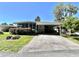 Cozy home featuring a screened-in porch, driveway with covered parking, and well-maintained landscaping at 104 Valencia Cv, Leesburg, FL 34748