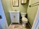 Charming half bathroom with a classic toilet and vanity, plus traditional green walls at 104 Valencia Cv, Leesburg, FL 34748