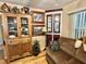 Charming living room detail showcasing a china cabinet with glass doors, decor and a sofa at 104 Valencia Cv, Leesburg, FL 34748