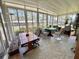 Bright sunroom with tile flooring and abundant light, and various tables and seating options at 104 Valencia Cv, Leesburg, FL 34748