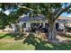 Large backyard showcasing an outdoor patio with seating, a barbecue grill and shade tree at 106 Baytree Blvd, Tavares, FL 32778