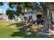 Wide view of the backyard featuring a brick patio, shade tree, and barbecue grill at 106 Baytree Blvd, Tavares, FL 32778