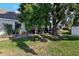 Spacious backyard featuring a lush lawn, mature tree, and patio seating area at 106 Baytree Blvd, Tavares, FL 32778