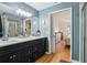 Modern bathroom featuring a double vanity, walk-in shower, and blue walls at 106 Baytree Blvd, Tavares, FL 32778