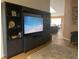 Cozy living room with built-in shelving, a large television, and a glimpse into the dining area at 106 Baytree Blvd, Tavares, FL 32778