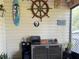Screened porch area featuring nautical themed art, speakers, and mini fridge for drinks at 106 Baytree Blvd, Tavares, FL 32778
