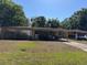 Cozy single-story home featuring a well-kept lawn and attached carport at 1108 Oak Dr, Leesburg, FL 34748