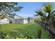 Large backyard with green grass, mature trees, and a detached garage, perfect for outdoor activities at 1109 W Line St, Leesburg, FL 34748