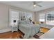 Cozy bedroom with hardwood floors, ceiling fan, and three bright windows at 1109 W Line St, Leesburg, FL 34748