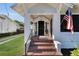 Inviting front porch with brick steps, elegant columns, and a classic American flag display at 1109 W Line St, Leesburg, FL 34748