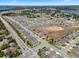 Scenic aerial shot of residential community showcasing harmoniously lined homes, lush greenery, and winding streets by a lake at 1128 Cavender Creek Rd, Minneola, FL 34715
