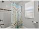 Clean bathroom showcasing a shower with a starfish-themed curtain and tile accents at 1128 Cavender Creek Rd, Minneola, FL 34715
