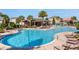 Community pool with lounge chairs, tables and chairs, nearby covered patio and playground at 1128 Cavender Creek Rd, Minneola, FL 34715