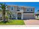 Charming two-story home featuring a well-manicured lawn, brick driveway, and welcoming front entrance at 1128 Cavender Creek Rd, Minneola, FL 34715