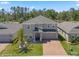 Charming two-story home featuring a well-manicured lawn, brick driveway, and welcoming front entrance at 1128 Cavender Creek Rd, Minneola, FL 34715