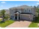 Charming two-story home featuring a well-manicured lawn, brick driveway, and welcoming front entrance at 1128 Cavender Creek Rd, Minneola, FL 34715