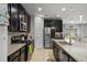Modern kitchen features granite countertops, stainless steel appliances, dark cabinets, and a pantry at 1128 Cavender Creek Rd, Minneola, FL 34715