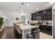 Open kitchen boasts granite countertops, a center island with seating, and black cabinets at 1128 Cavender Creek Rd, Minneola, FL 34715