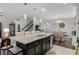Spacious kitchen island with pendant lighting, granite counters, and seating overlooking the dining area at 1128 Cavender Creek Rd, Minneola, FL 34715