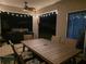 Evening view of covered patio with dining table, ceiling fan, and backyard ambiance at 1128 Cavender Creek Rd, Minneola, FL 34715