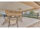 Covered patio with several tables, chairs, ceiling fan, and manicured landscaping at 1128 Cavender Creek Rd, Minneola, FL 34715