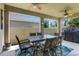 Covered patio offers an outdoor dining table, ceiling fans, and view of backyard at 1128 Cavender Creek Rd, Minneola, FL 34715