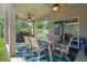 Covered patio featuring ceiling fans, outdoor dining table, and a view of the manicured lawn at 1128 Cavender Creek Rd, Minneola, FL 34715