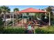 Elevated view of a fenced playground with shade coverings, slides, and climbing structures at 1128 Cavender Creek Rd, Minneola, FL 34715