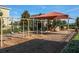 Community playground featuring swings, slides, and a sun shade at 1128 Cavender Creek Rd, Minneola, FL 34715