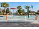 Up close, splash-pad view of pool with sprayers and buckets of water surrounded by palm trees and green landscaping at 1128 Cavender Creek Rd, Minneola, FL 34715