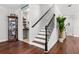 Elegant staircase with wood treads and decorative iron railings, alongside a display cabinet at 1128 Cavender Creek Rd, Minneola, FL 34715